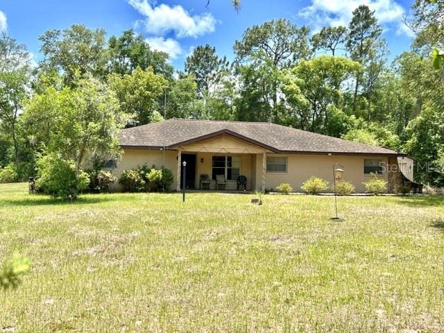 20100 SW 95th St, Dunnellon, FL 34431 - ranch-style house featuring a front lawn and stucco siding