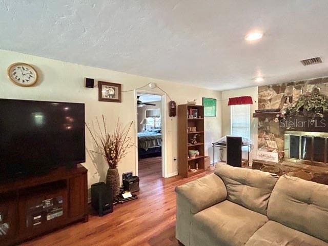 20100 SW 95th St, Dunnellon, FL 34431 - living room with wood finished floors, ceiling fan, and a stone fireplace