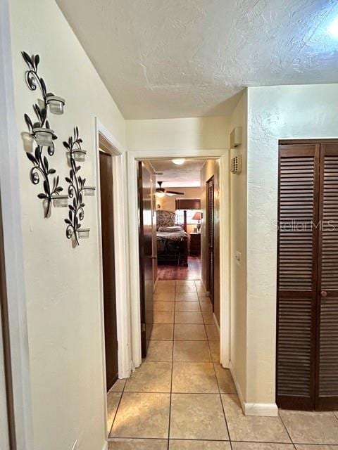 20100 SW 95th St, Dunnellon, FL 34431 - hall featuring light tile patterned flooring, a textured ceiling, and baseboards
