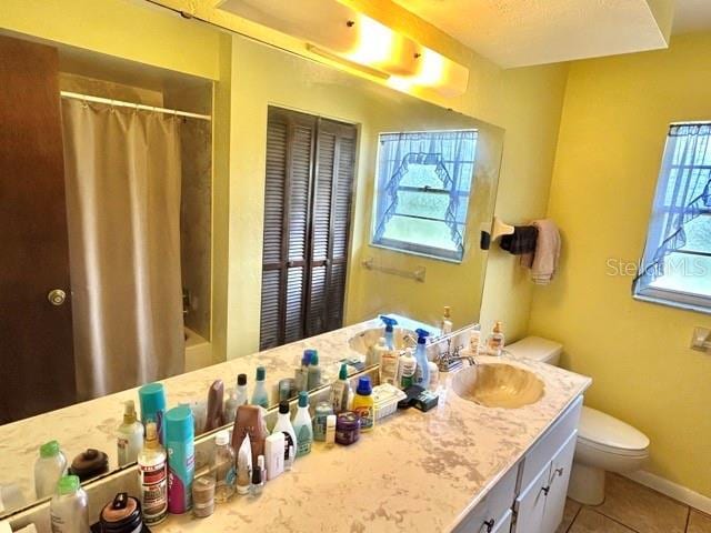 20100 SW 95th St, Dunnellon, FL 34431 - full bath featuring toilet, double vanity, tile patterned flooring, and baseboards