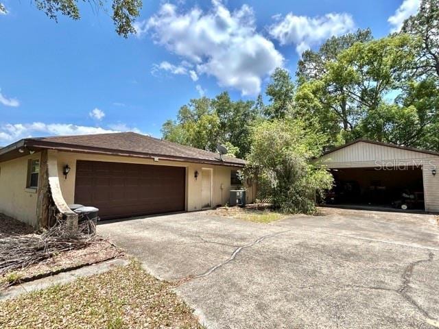 20100 SW 95th St, Dunnellon, FL 34431 - view of side of property with central AC, stucco siding, and driveway