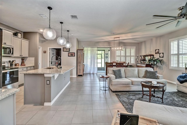 6405 SW 88th Loop, Ocala, FL 34476 - kitchen featuring appliances with stainless steel finishes, open floor plan, ceiling fan, and light tile patterned flooring