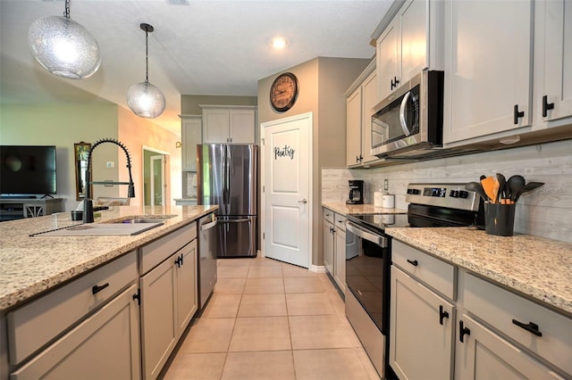 6405 SW 88th Loop, Ocala, FL 34476 - kitchen featuring appliances with stainless steel finishes, light tile patterned floors, tasteful backsplash, pendant lighting, and light stone countertops
