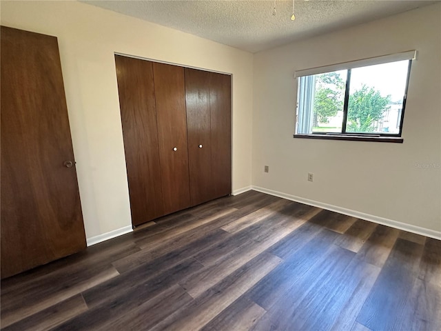 10080 SW 97th Ct, Ocala, FL 34481 - unfurnished bedroom featuring a closet, dark wood-style flooring, a textured ceiling, and baseboards