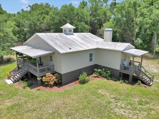 12080 SE Sunset Harbor Rd, Weirsdale, FL 32195 - view of side of home featuring stairs, a porch, a yard, and a metal roof