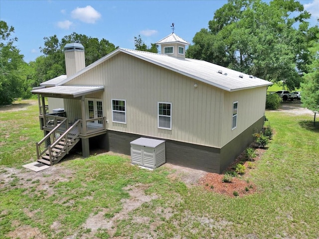 12080 SE Sunset Harbor Rd, Weirsdale, FL 32195 - back of house with a lawn, french doors, a chimney, a metal roof, and a deck