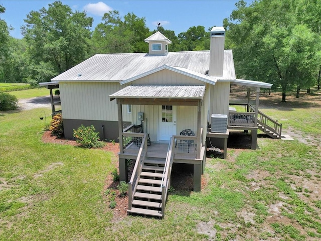 12080 SE Sunset Harbor Rd, Weirsdale, FL 32195 - view of front of home with stairway, a metal roof, a chimney, a front lawn, and a deck