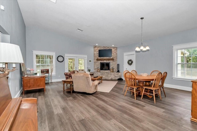 12080 SE Sunset Harbor Rd, Weirsdale, FL 32195 - living area featuring dark wood-type flooring, a stone fireplace, a chandelier, and high vaulted ceiling