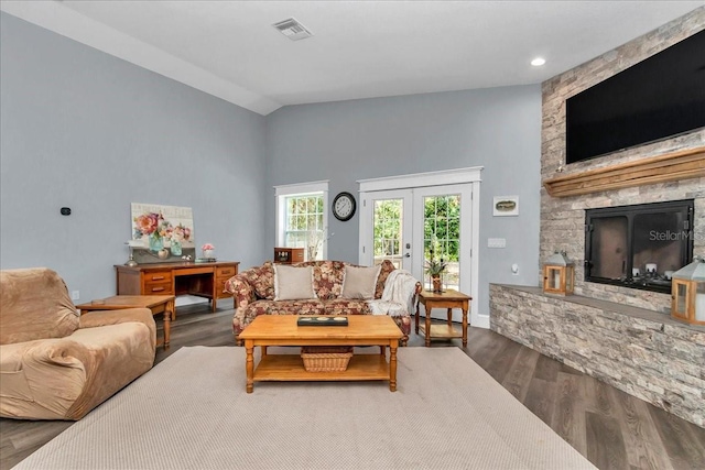 12080 SE Sunset Harbor Rd, Weirsdale, FL 32195 - living room featuring wood finished floors, high vaulted ceiling, a stone fireplace, and french doors