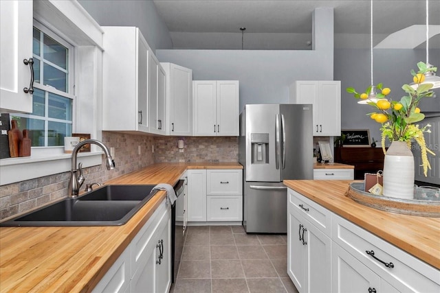 12080 SE Sunset Harbor Rd, Weirsdale, FL 32195 - kitchen featuring wood counters, appliances with stainless steel finishes, light tile patterned floors, and backsplash