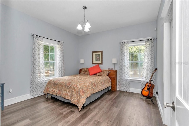 12080 SE Sunset Harbor Rd, Weirsdale, FL 32195 - bedroom featuring a chandelier and wood finished floors