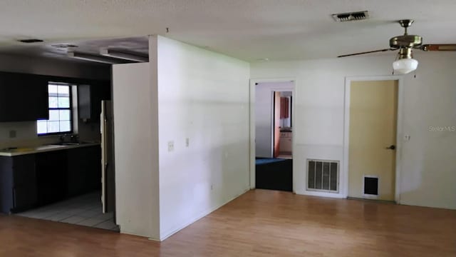 8485 E Hampton Point Rd, Inverness, FL 34450 - unfurnished living room with light wood-style floors, a ceiling fan, and a sink