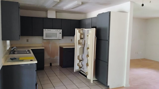 8485 E Hampton Point Rd, Inverness, FL 34450 - kitchen featuring white appliances, a sink, dark cabinetry, light countertops, and light tile patterned flooring