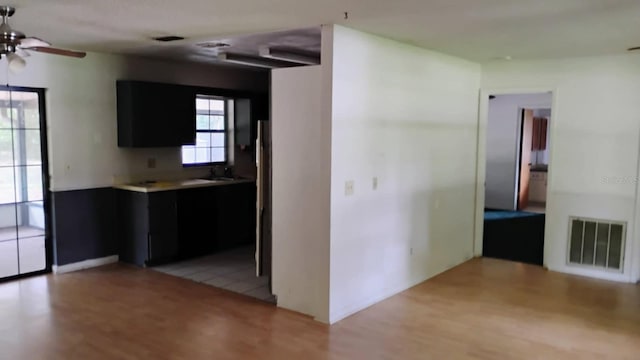 8485 E Hampton Point Rd, Inverness, FL 34450 - kitchen with light wood-style flooring, ceiling fan, and dark cabinetry