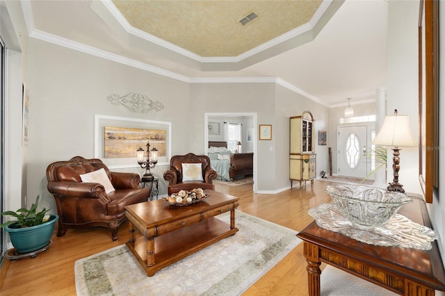 8737 SW 83rd Cir, Ocala, FL 34481 - living room featuring a tray ceiling, light wood-style floors, ornamental molding, and baseboards