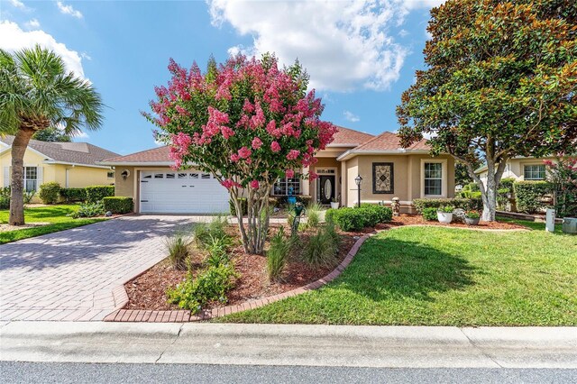 8737 SW 83rd Cir, Ocala, FL 34481 - obstructed view of property featuring a garage, stucco siding, a front yard, and driveway