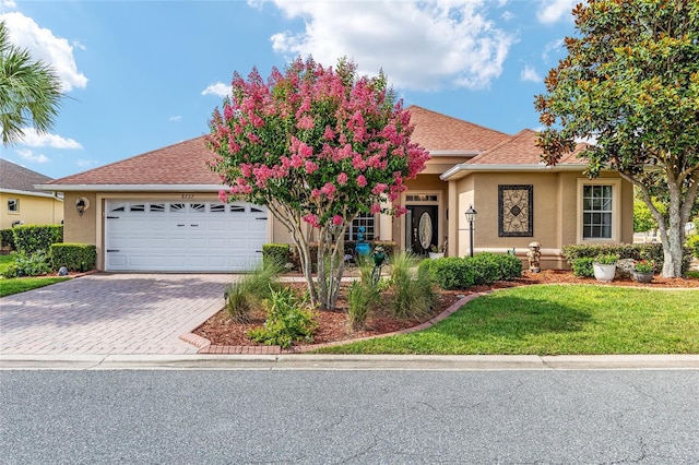 8737 SW 83rd Cir, Ocala, FL 34481 - view of front of home with a garage, stucco siding, driveway, and a front yard