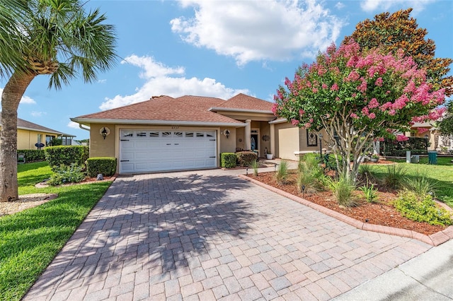 8737 SW 83rd Cir, Ocala, FL 34481 - view of front of home featuring stucco siding, a garage, decorative driveway, and roof with shingles