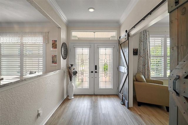 8772 SE 130th Loop, Summerfield, FL 34491 - foyer with a barn door, wood finished floors, french doors, ornamental molding, and a textured wall