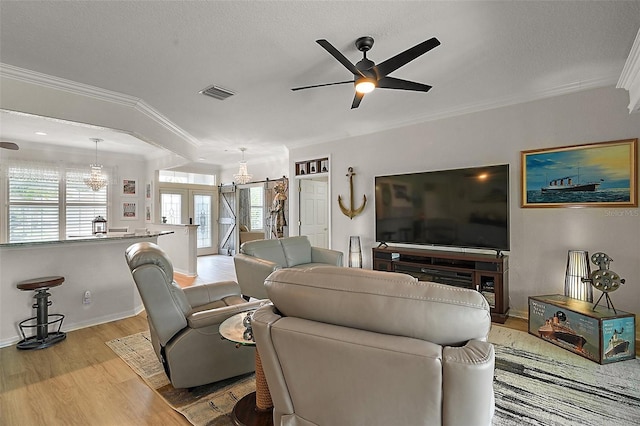 8772 SE 130th Loop, Summerfield, FL 34491 - living area featuring light wood finished floors, ornamental molding, a chandelier, ceiling fan, and a textured ceiling