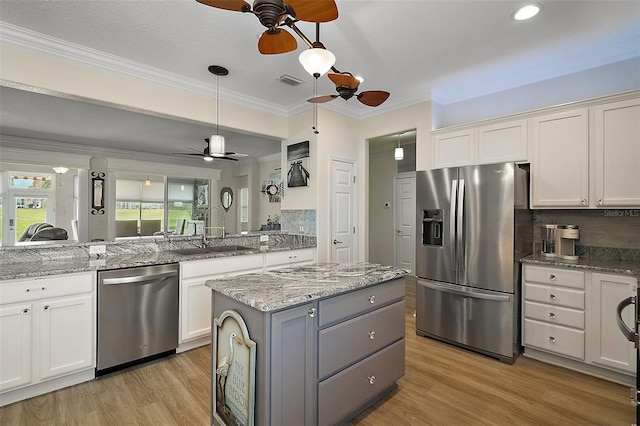 8772 SE 130th Loop, Summerfield, FL 34491 - kitchen featuring appliances with stainless steel finishes, ceiling fan, a sink, light wood finished floors, and ornamental molding