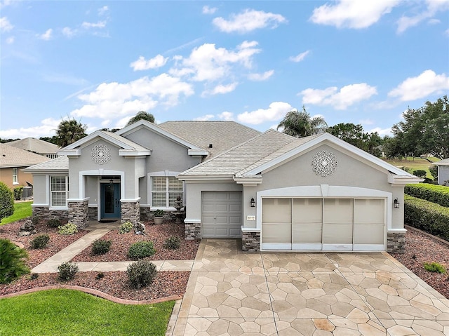 8772 SE 130th Loop, Summerfield, FL 34491 - view of front facade featuring stone siding, stucco siding, an attached garage, concrete driveway, and a shingled roof