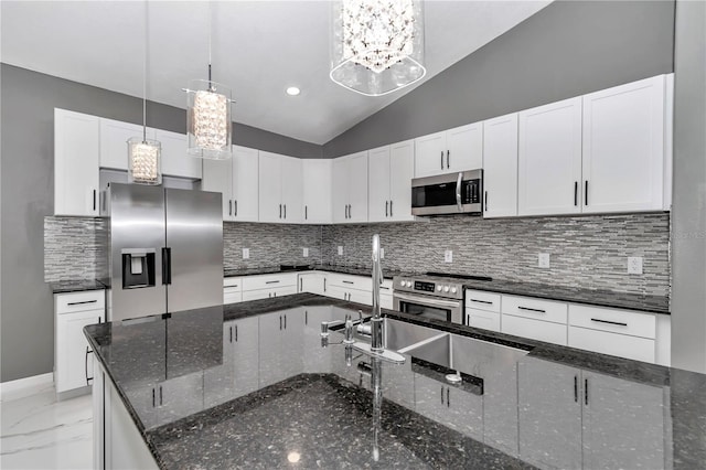 14550 SW 61st Ct, Ocala, FL 34473 - kitchen featuring stainless steel appliances, vaulted ceiling, tasteful backsplash, pendant lighting, and white cabinetry