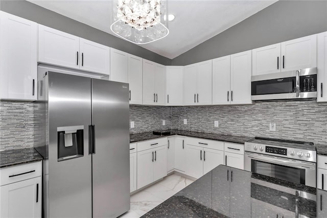 14550 SW 61st Ct, Ocala, FL 34473 - kitchen with appliances with stainless steel finishes, light marble finish flooring, white cabinetry, dark stone counters, and lofted ceiling