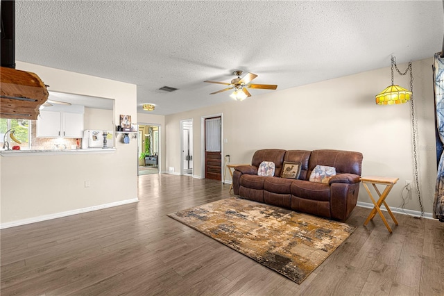 5005 NE 22nd Ave, Ocala, FL 34479 - living area featuring a ceiling fan, wood finished floors, a textured ceiling, and baseboards