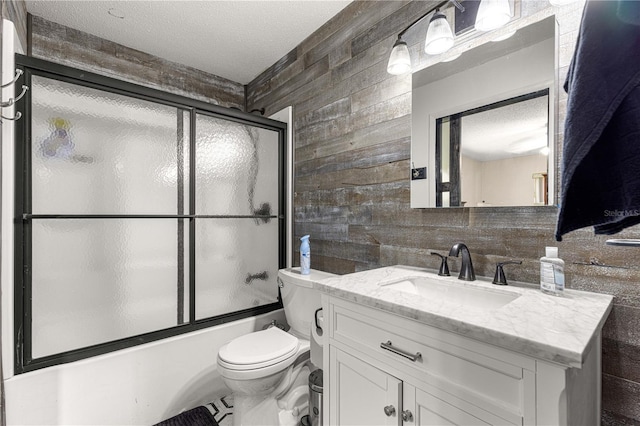 5005 NE 22nd Ave, Ocala, FL 34479 - full bathroom featuring vanity, toilet, wooden walls, enclosed tub / shower combo, and a textured ceiling