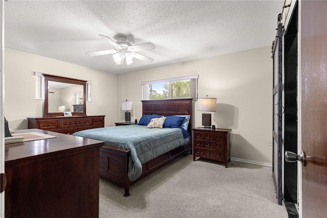 5005 NE 22nd Ave, Ocala, FL 34479 - bedroom featuring light carpet, a textured ceiling, a ceiling fan, baseboards, and a barn door
