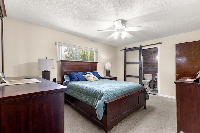 5005 NE 22nd Ave, Ocala, FL 34479 - bedroom with light carpet, a barn door, a textured ceiling, a ceiling fan, and connected bathroom