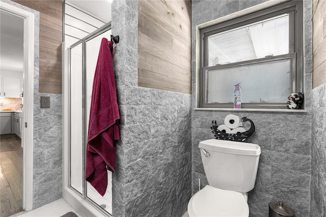 5005 NE 22nd Ave, Ocala, FL 34479 - bathroom with a stall shower, toilet, tile walls, and wood finished floors