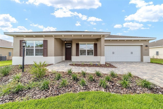10562 SW 96th Lane Rd, Ocala, FL 34481 - ranch-style house with stucco siding, decorative driveway, a garage, and cooling unit