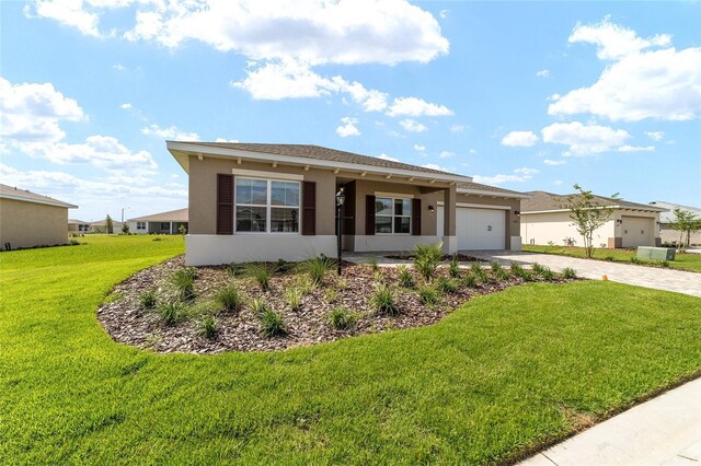 10562 SW 96th Lane Rd, Ocala, FL 34481 - view of front of home with driveway, stucco siding, a garage, and a front yard