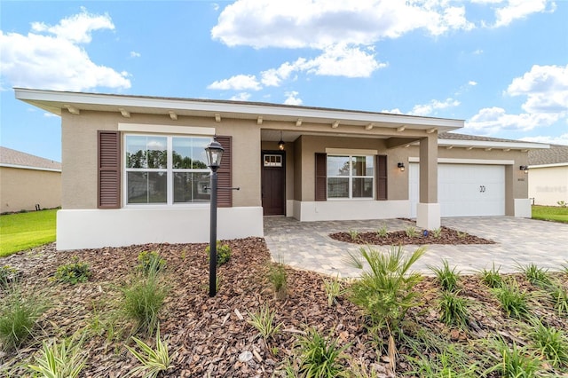 10562 SW 96th Lane Rd, Ocala, FL 34481 - view of front of home featuring stucco siding, an attached garage, and decorative driveway