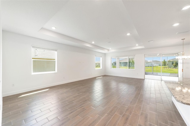 10562 SW 96th Lane Rd, Ocala, FL 34481 - empty room with a raised ceiling, recessed lighting, baseboards, wood finished floors, and a chandelier
