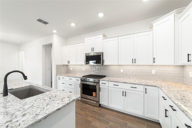 10562 SW 96th Lane Rd, Ocala, FL 34481 - kitchen with appliances with stainless steel finishes, a sink, backsplash, white cabinetry, and recessed lighting