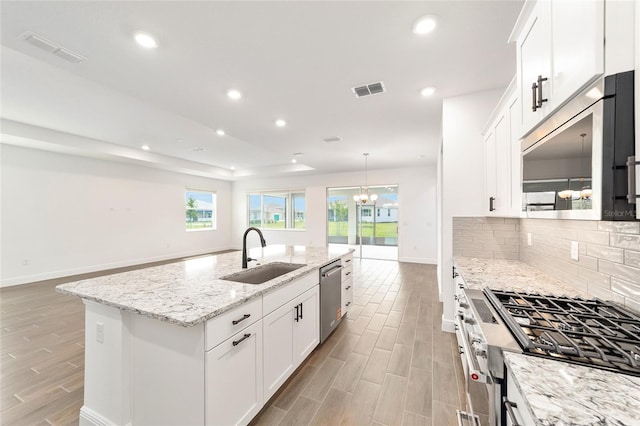10562 SW 96th Lane Rd, Ocala, FL 34481 - kitchen with a sink, appliances with stainless steel finishes, baseboards, light wood-style flooring, and decorative backsplash
