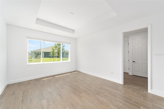 10562 SW 96th Lane Rd, Ocala, FL 34481 - spare room featuring a tray ceiling, light wood-type flooring, and baseboards