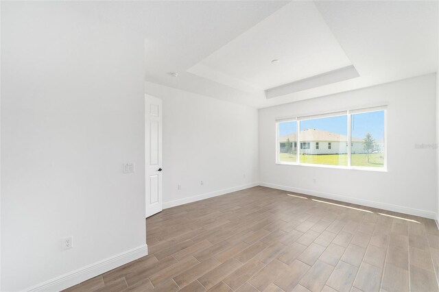 10562 SW 96th Lane Rd, Ocala, FL 34481 - empty room featuring a tray ceiling, baseboards, and wood finished floors