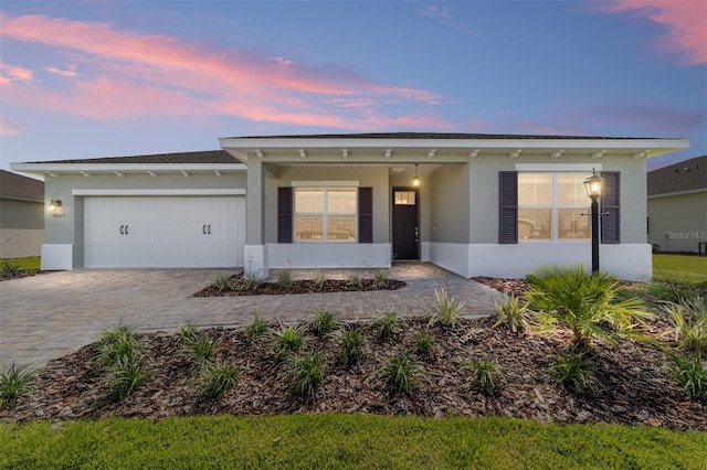 9865 SW 105th Ct, Ocala, FL 34481 - ranch-style home with stucco siding, a garage, and decorative driveway