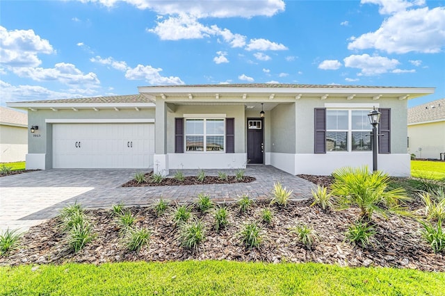 9865 SW 105th Ct, Ocala, FL 34481 - ranch-style house featuring stucco siding, an attached garage, and decorative driveway