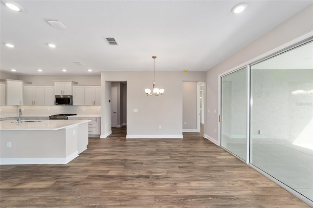 9865 SW 105th Ct, Ocala, FL 34481 - kitchen featuring appliances with stainless steel finishes, a sink, a chandelier, wood finished floors, and white cabinets