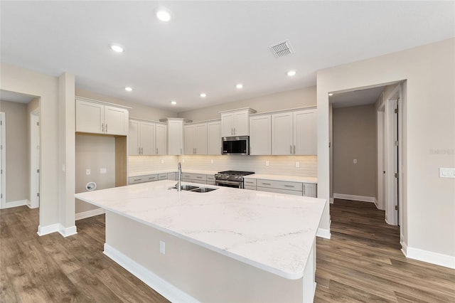 9865 SW 105th Ct, Ocala, FL 34481 - kitchen with appliances with stainless steel finishes, a sink, baseboards, decorative backsplash, and an island with sink