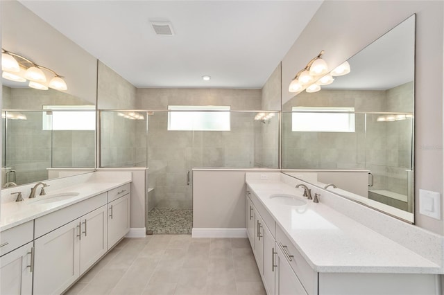 9865 SW 105th Ct, Ocala, FL 34481 - bathroom featuring healthy amount of natural light, two vanities, a shower stall, and tile patterned floors