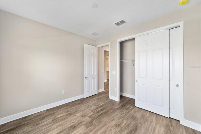 9865 SW 105th Ct, Ocala, FL 34481 - unfurnished bedroom with wood finished floors, baseboards, and a closet
