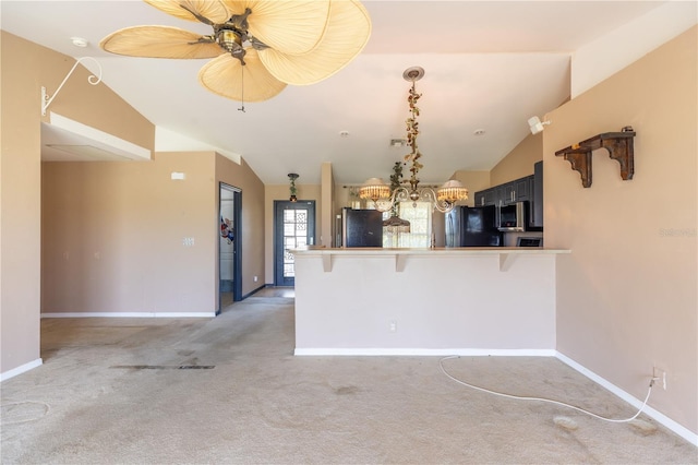 3019 NW Juanita Pl, Cape Coral, FL 33993 - kitchen with freestanding refrigerator, lofted ceiling, stainless steel microwave, light carpet, and a peninsula