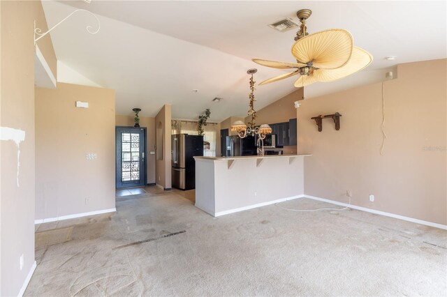 3019 NW Juanita Pl, Cape Coral, FL 33993 - kitchen with freestanding refrigerator, fridge with ice dispenser, a peninsula, lofted ceiling, and light carpet