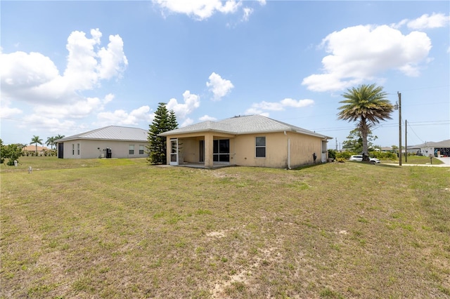 3019 NW Juanita Pl, Cape Coral, FL 33993 - rear view of property featuring a yard and stucco siding